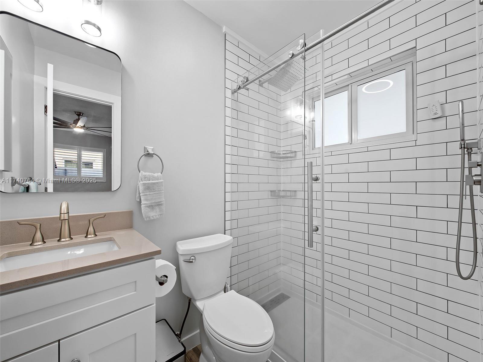 413 Southeast 4th Terrace Dania Beach, FL 33004 - Photo 14 of 25 a bathroom with a toilet sink vanity and mirror