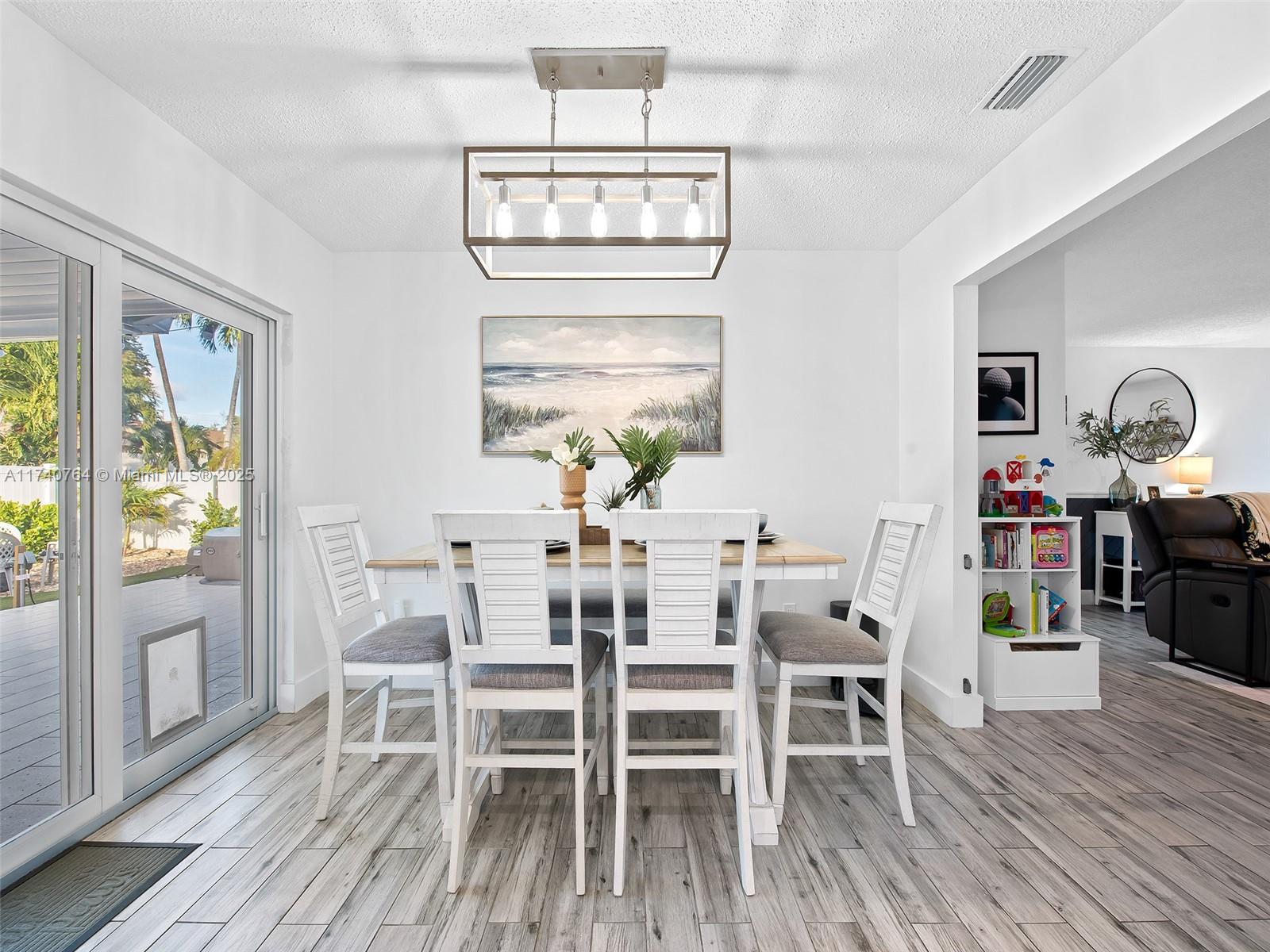 413 Southeast 4th Terrace Dania Beach, FL 33004 - Photo 10 of 25 a view of a dining room with furniture a chandelier and wooden floor