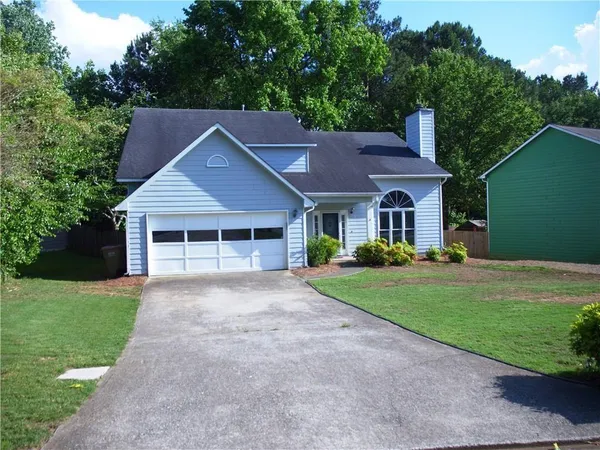 a front view of a house with a yard and trees