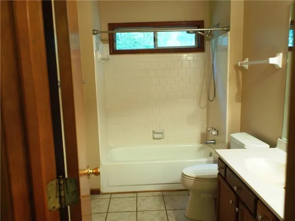 a bathroom with a granite countertop bathtub shower sink vanity and toilet