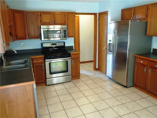 a kitchen with stainless steel appliances granite countertop a refrigerator stove and microwave