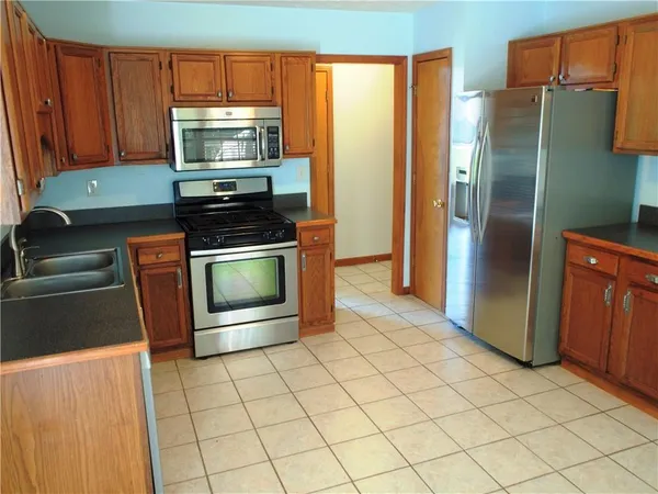 a kitchen with stainless steel appliances granite countertop a refrigerator stove and microwave