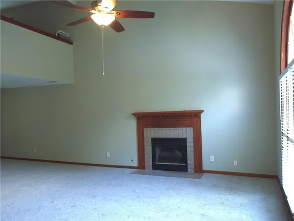 an empty room with a fireplace and window