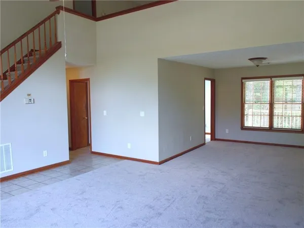 a view of an empty room with windows & cabinet