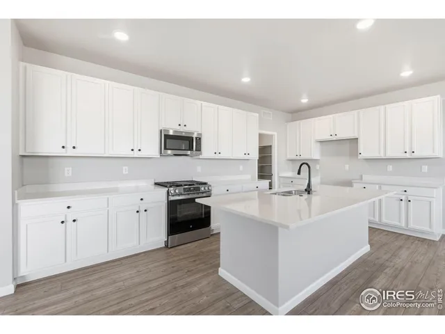 a large white kitchen with cabinets