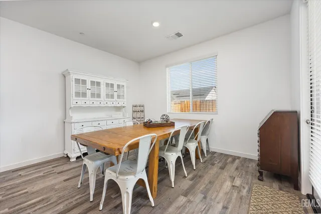 a open dining room with stainless steel appliances a table and chairs