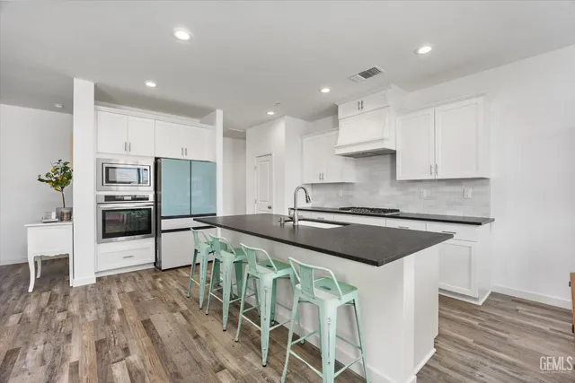 a kitchen with granite countertop white cabinets and white appliances