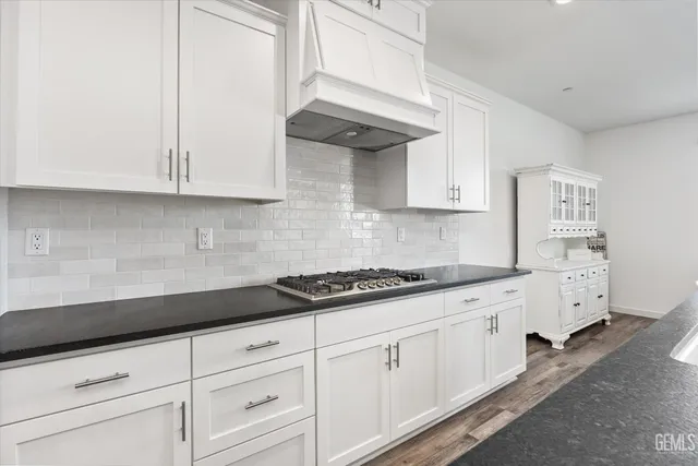 a kitchen with granite countertop stainless steel appliances a sink stove and refrigerator