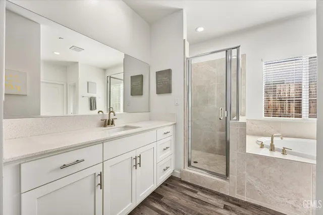 a bathroom with a tub a sink and a window