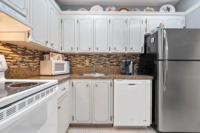 a kitchen with appliances a sink and cabinets