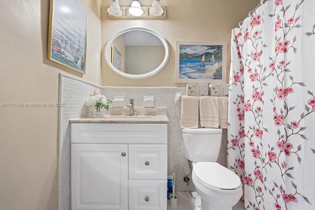 a bathroom with a granite countertop toilet sink and mirror