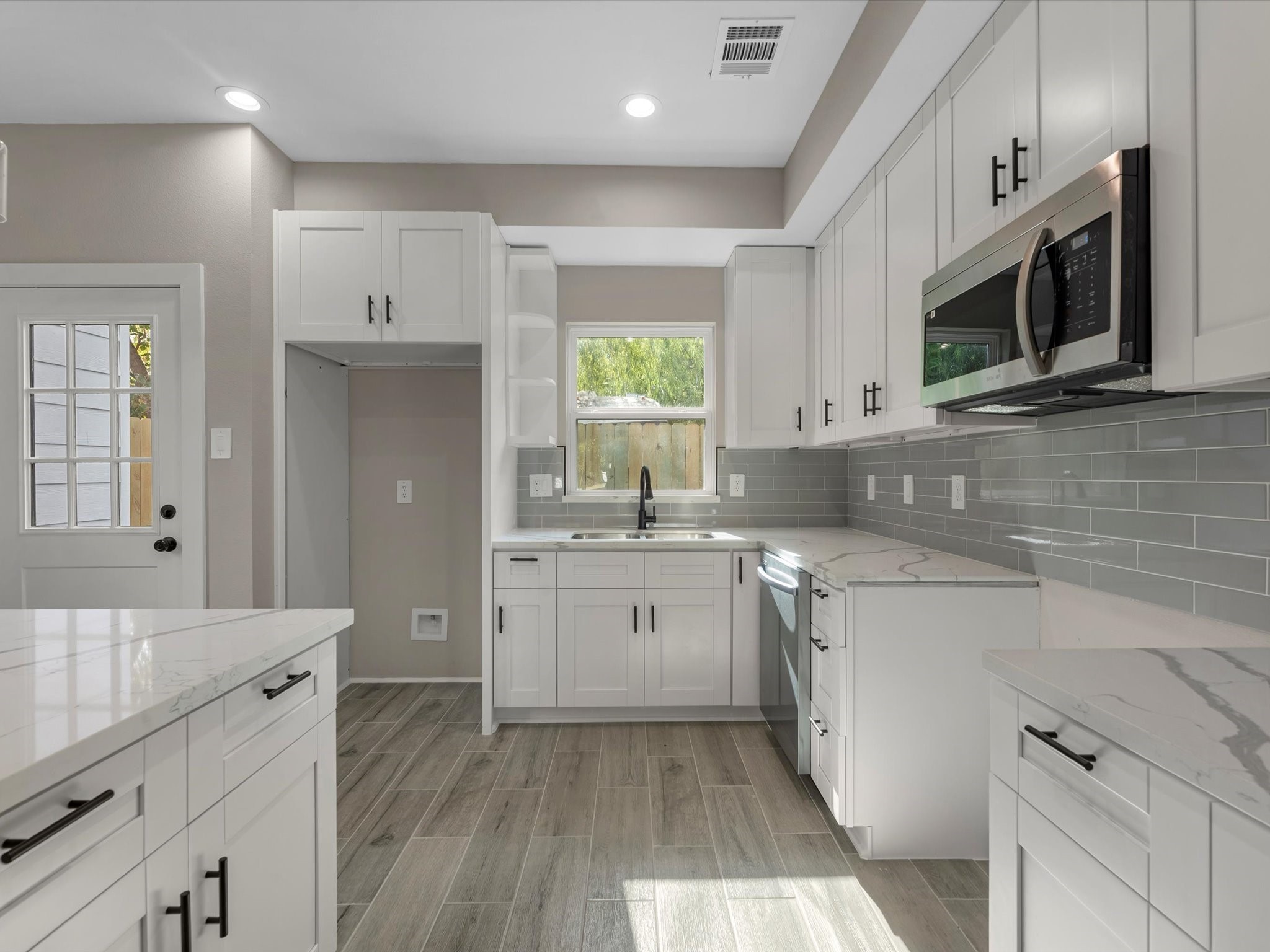 7802 Queen Street, Unit A Houston, TX 77028 - Photo 12 of 40 a kitchen with stainless steel appliances granite countertop a sink dishwasher a stove and a microwave oven with cabinets