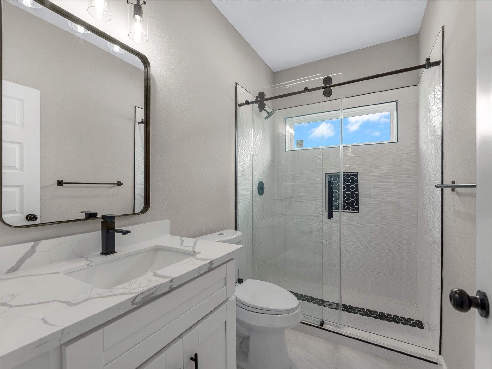 7802 Queen Street, Unit A Houston, TX 77028 - Photo 18 of 40 a bathroom with a shower sink vanity mirror and toilet