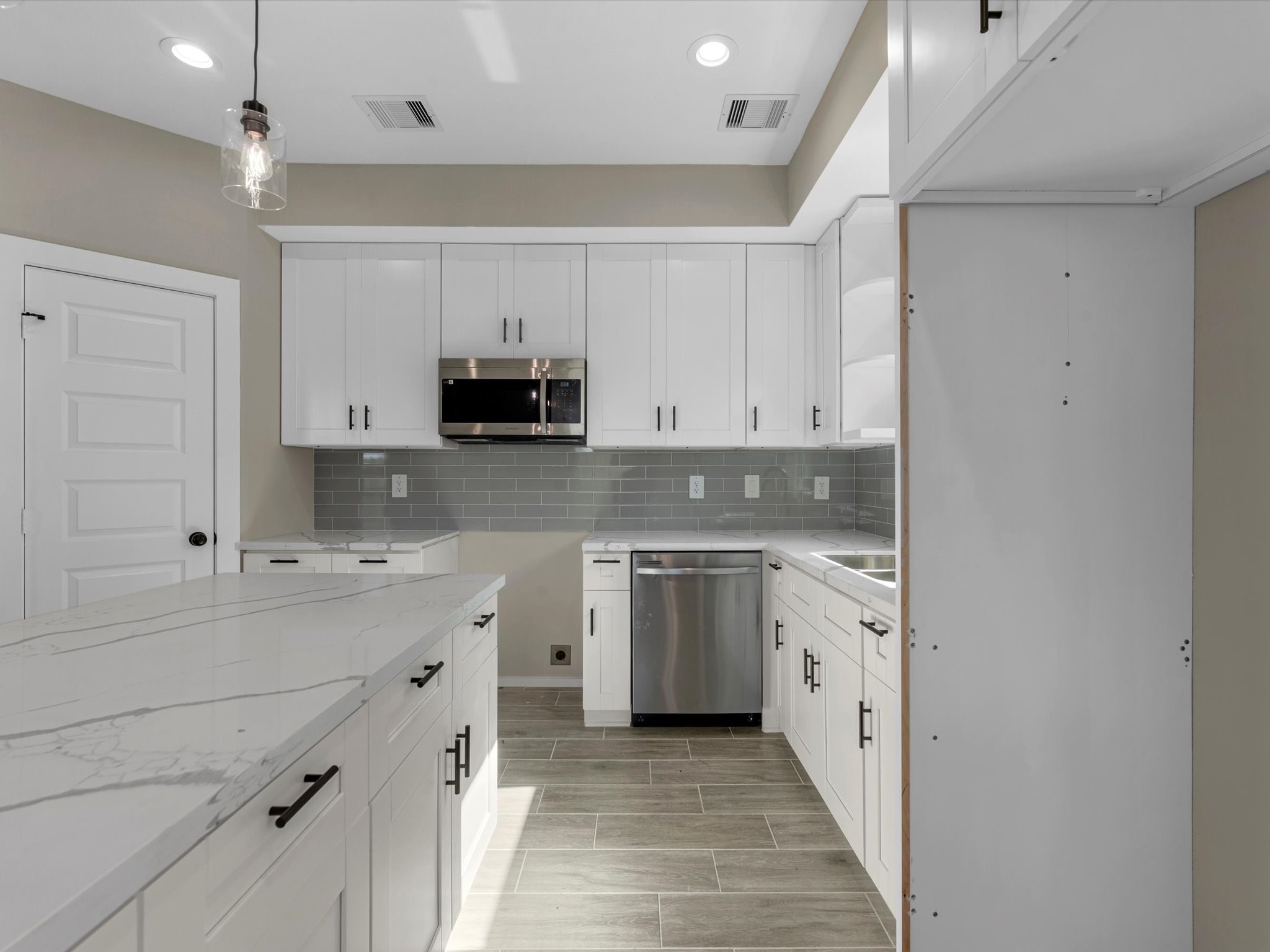 7802 Queen Street, Unit A Houston, TX 77028 - Photo 29 of 40 a kitchen with stainless steel appliances granite countertop a stove top oven a sink and dishwasher with white cabinets