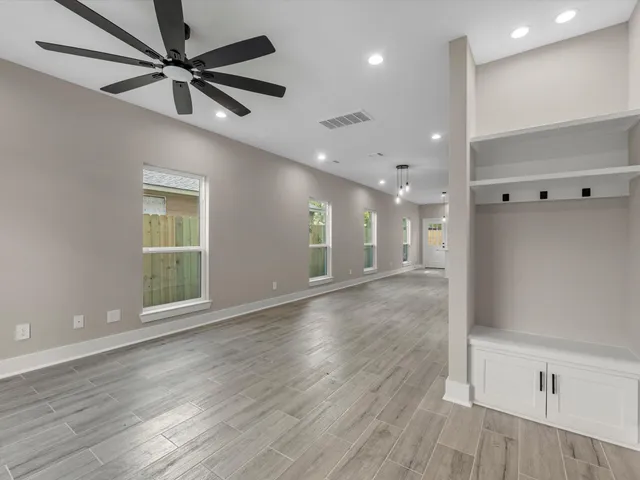 a view of an empty room and kitchen view