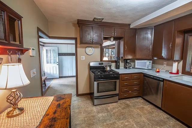 a kitchen with stainless steel appliances granite countertop a stove a sink and a microwave