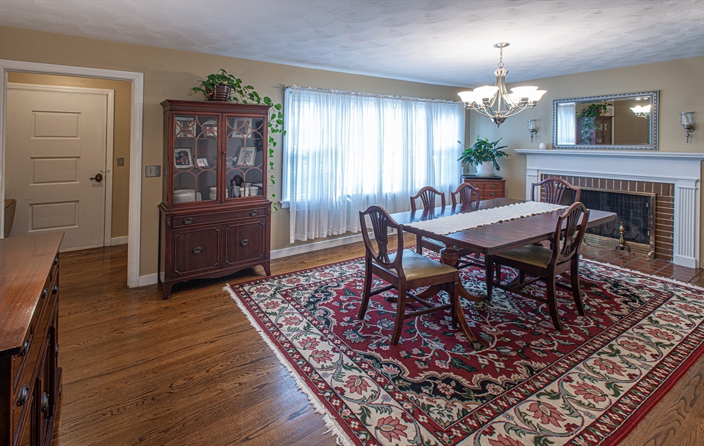 54 South Shore Drive Springfield, MA 01118 - Photo 20 of 39 a dining room with wooden floor a chandelier a wooden table and chairs