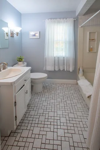 a bathroom with a sink a toilet and a mirror