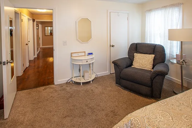 a living room with furniture a mirror and a lamp