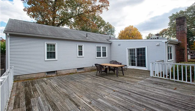 a view of a house with a wooden deck and a backyard