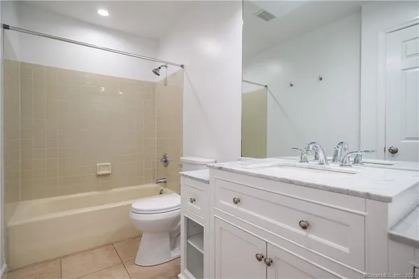 a bathroom with a granite countertop sink toilet a mirror and shower