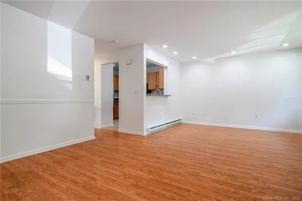 a view of an empty room with wooden floor