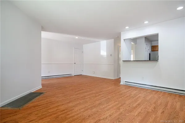 a view of an empty room with wooden floor