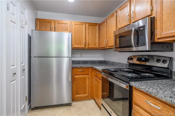 a kitchen with stainless steel appliances granite countertop a refrigerator stove and microwave