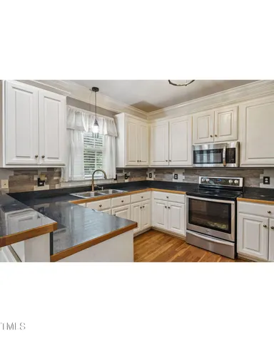 a view of a kitchen with granite countertop white cabinets and sink