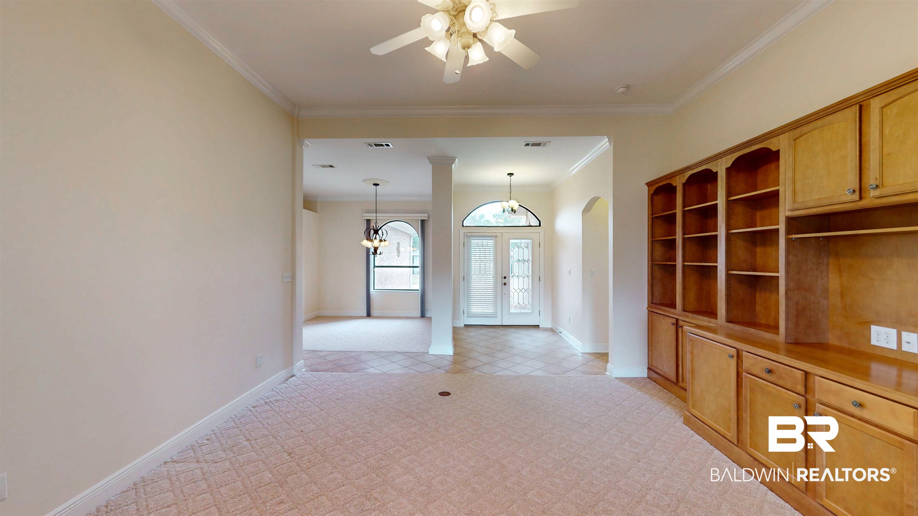 214 Hemingway Loop Foley, AL 36535 - Photo 9 of 67 Unfurnished living room featuring french doors, crown molding, a ceiling fan, arched walkways, and a chandelier