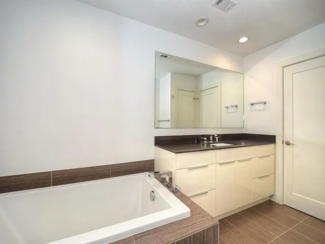 a bathroom with a tub sink and mirror