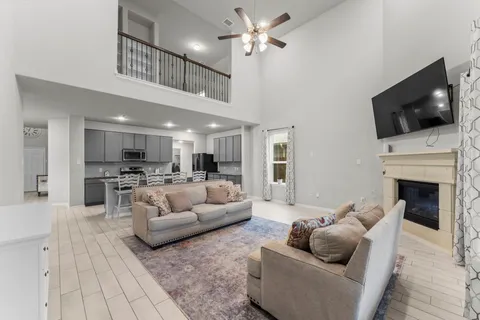 a living room with furniture a fireplace and a flat screen tv