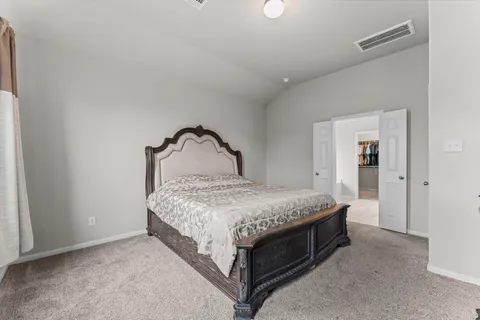 a bedroom with a bed and lamp