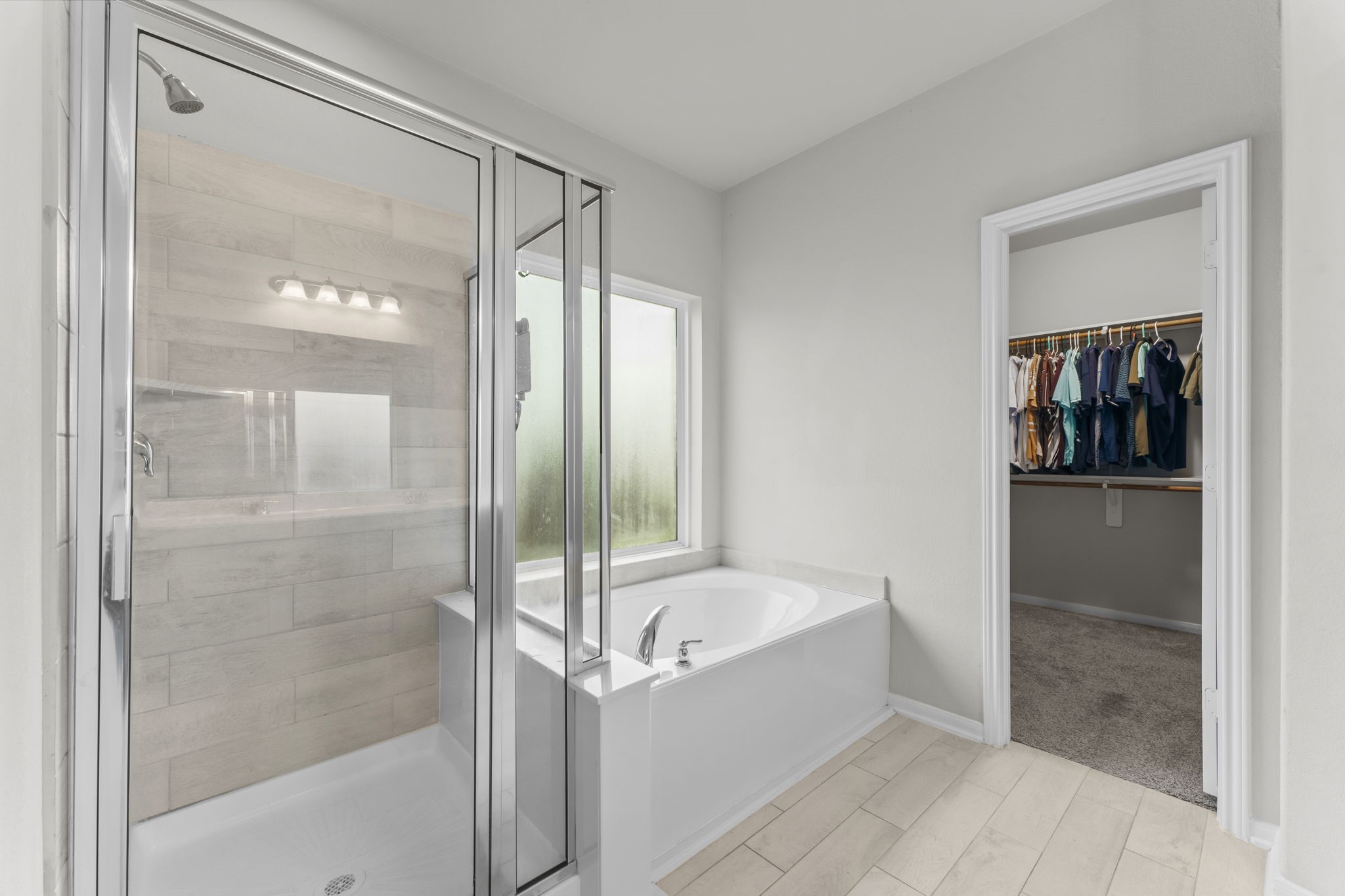 11331 Painted Trillium Lane Houston, TX 77044 - Photo 19 of 38 a bathroom with a bathtub and a shower