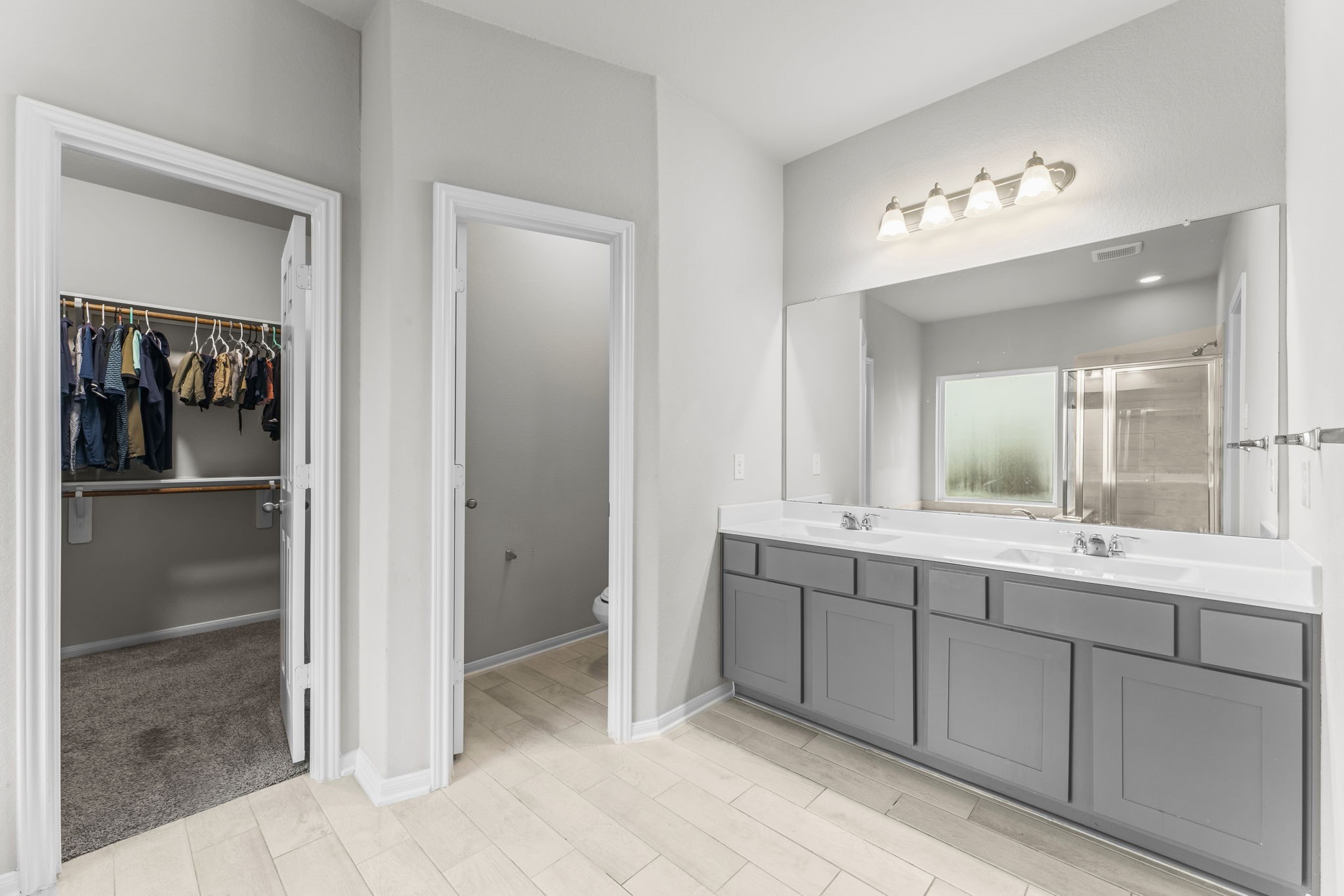 11331 Painted Trillium Lane Houston, TX 77044 - Photo 20 of 38 a bathroom with a double vanity sink and mirror