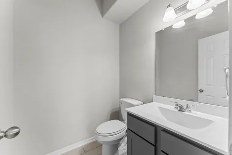 a bathroom with a toilet a sink and mirror