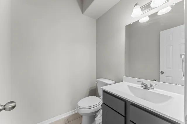 a bathroom with a toilet a sink and mirror