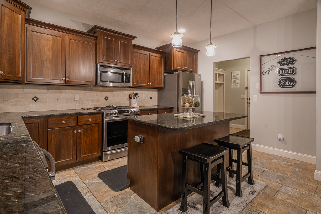 5107 Longfield Road Bloomington, IL 61705 - Photo 2 of 25 a kitchen with stainless steel appliances granite countertop wooden cabinets a refrigerator a stove a sink and a microwave