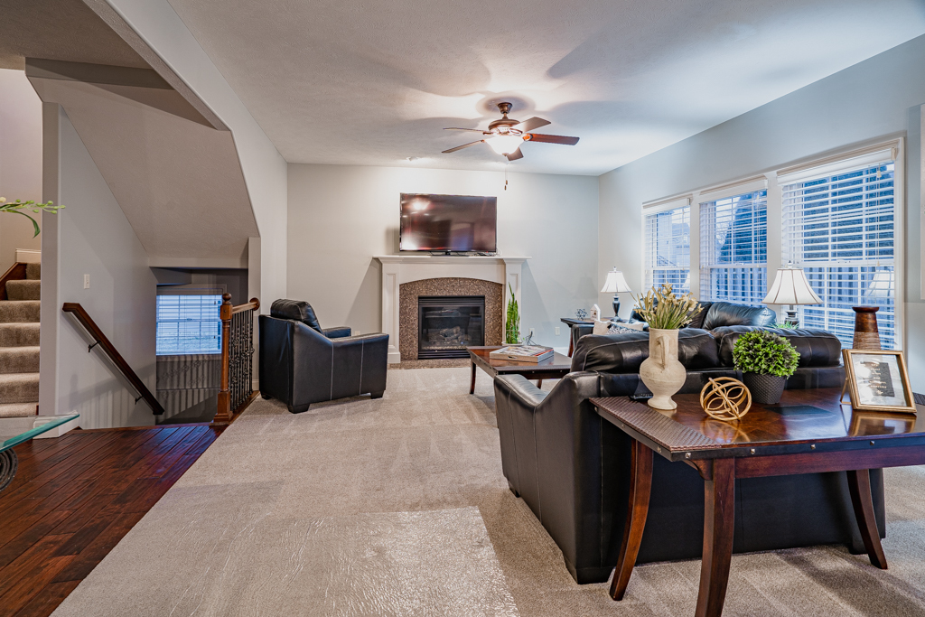 5107 Longfield Road Bloomington, IL 61705 - Photo 4 of 25 a living room with furniture a fireplace and a flat screen tv