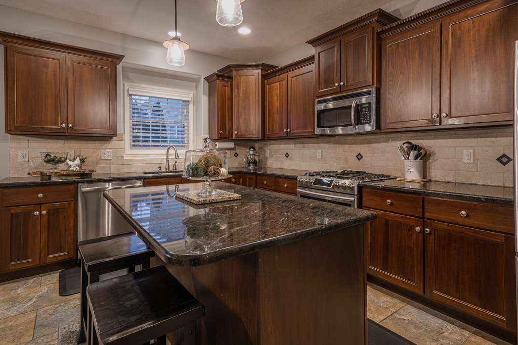 5107 Longfield Road Bloomington, IL 61705 - Photo 9 of 25 a kitchen with stainless steel appliances granite countertop a sink stove and microwave