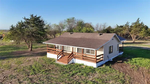 an aerial view of a house with porch yard basket ball court and trampoline