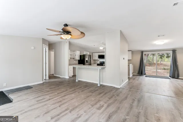 a view of a kitchen with wooden floor and a ceiling fan