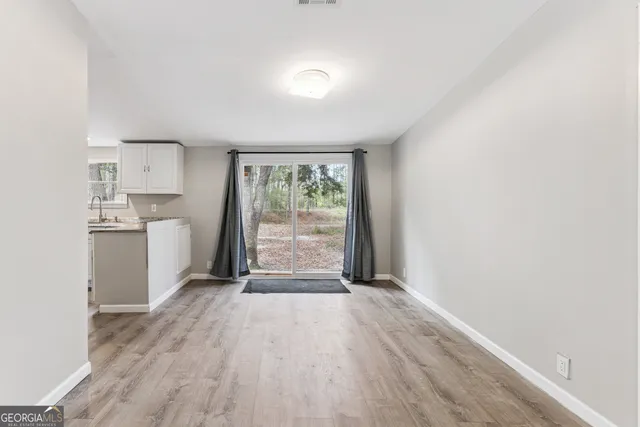 a view of a kitchen with wooden floor and electronic appliances