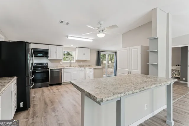a kitchen with a stove a refrigerator and a sink