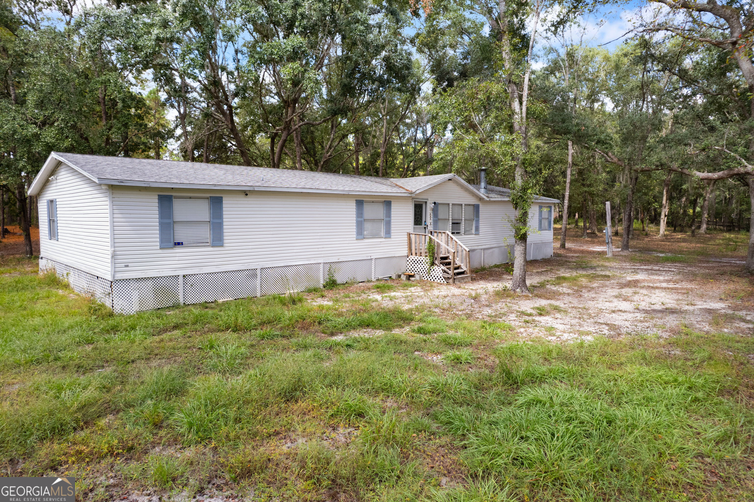 68 Amber Drive Waverly, GA 31565 - Photo 3 of 39 a view of a yard in front of a house with large trees