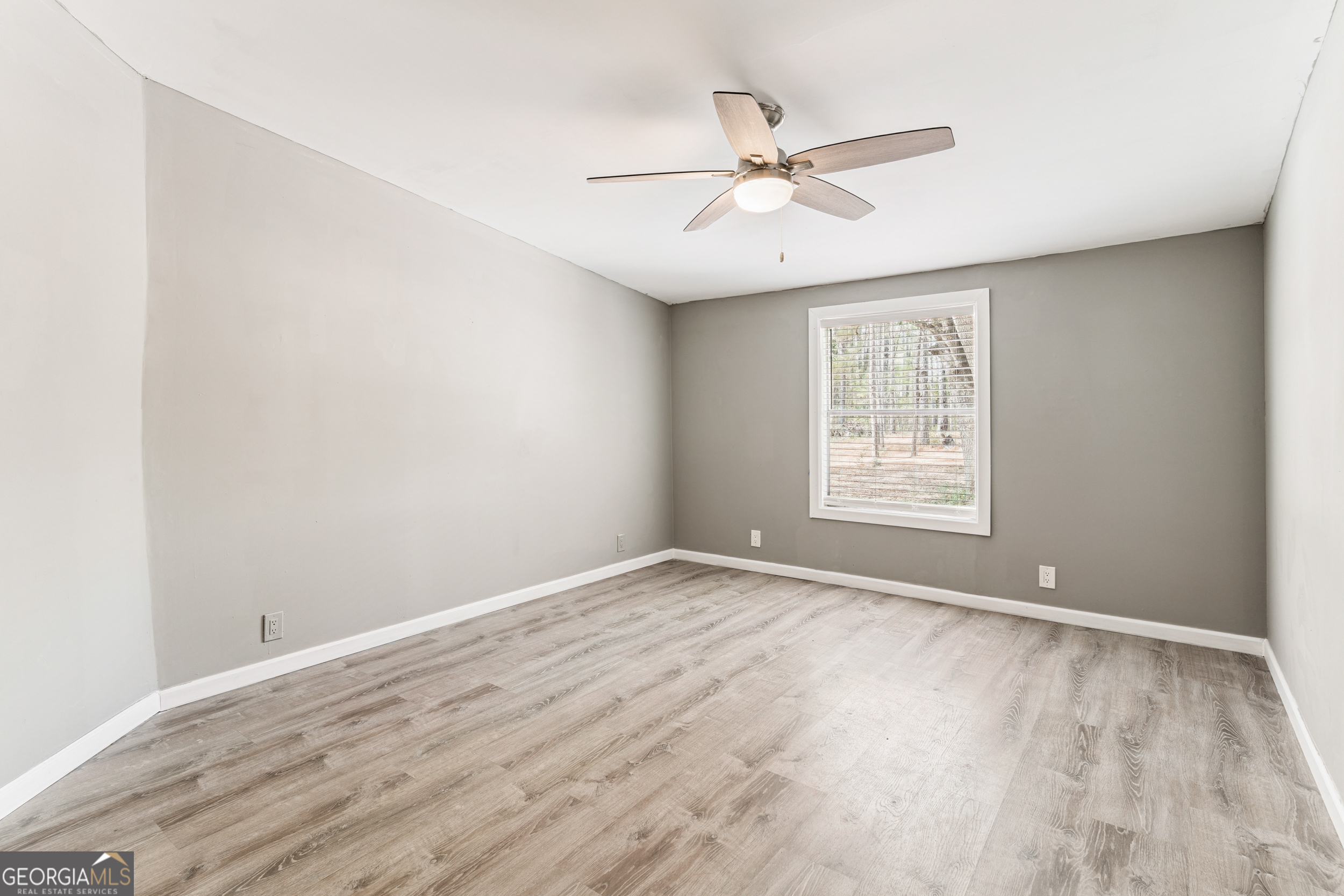 68 Amber Drive Waverly, GA 31565 - Photo 31 of 39 an empty room with wooden floor fan and windows