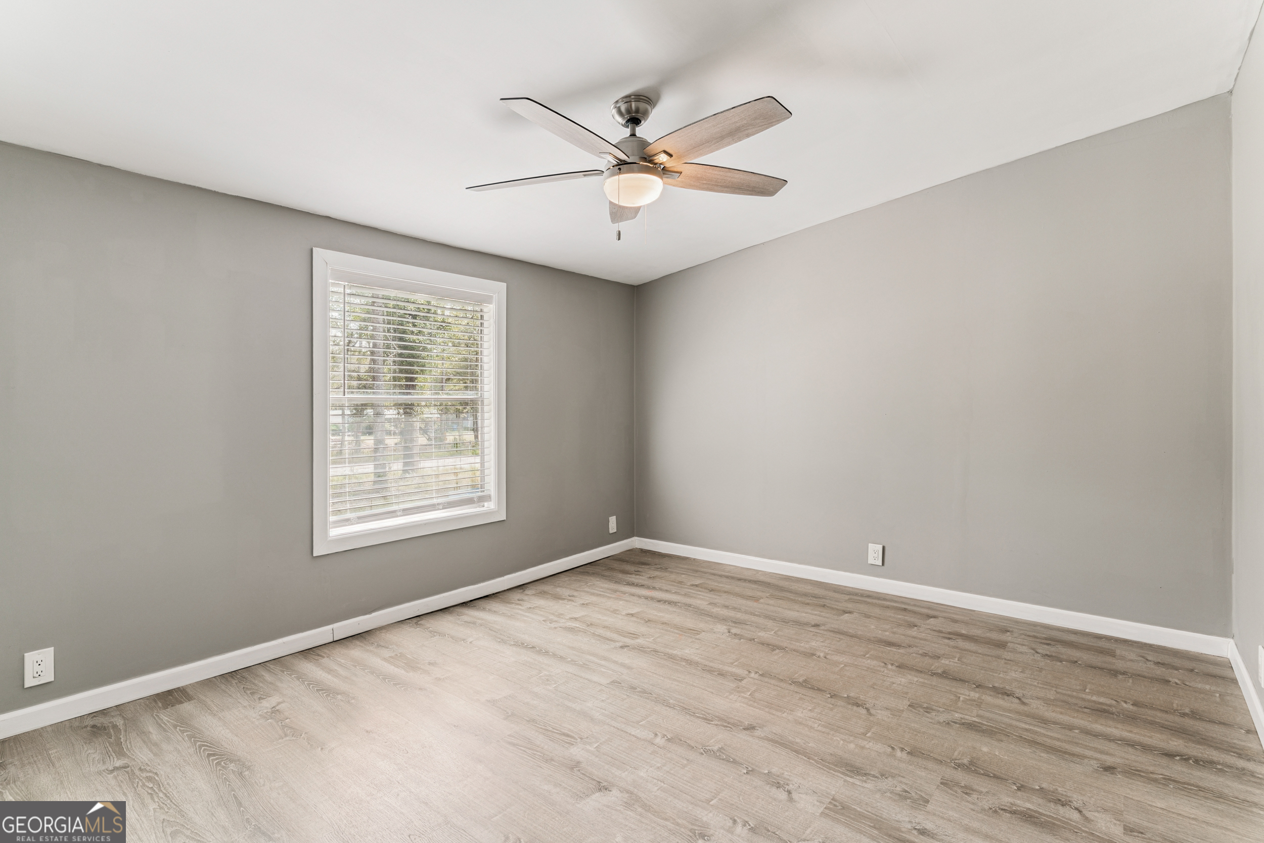 68 Amber Drive Waverly, GA 31565 - Photo 33 of 39 an empty room with wooden floor fan and windows