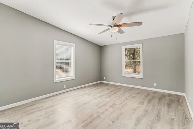 a view of a room with wooden floor and small window