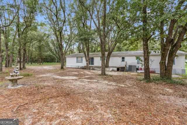 a view of a house with a yard and tree s