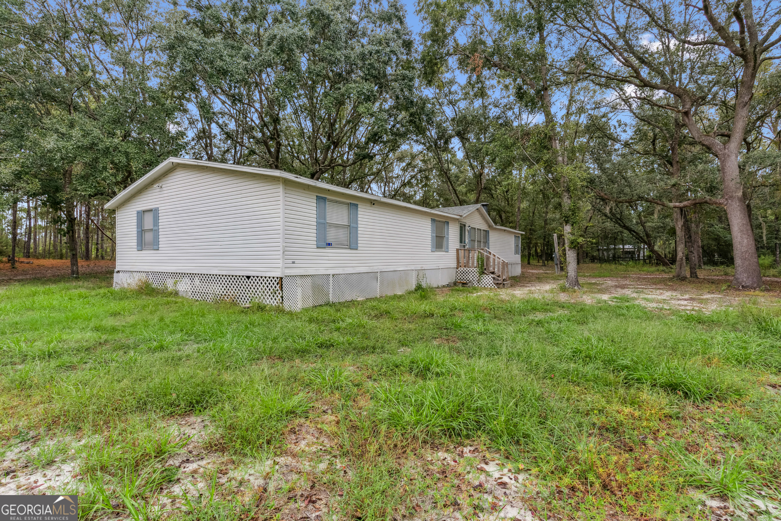 68 Amber Drive Waverly, GA 31565 - Photo 8 of 39 a white house that has a tree in front of it